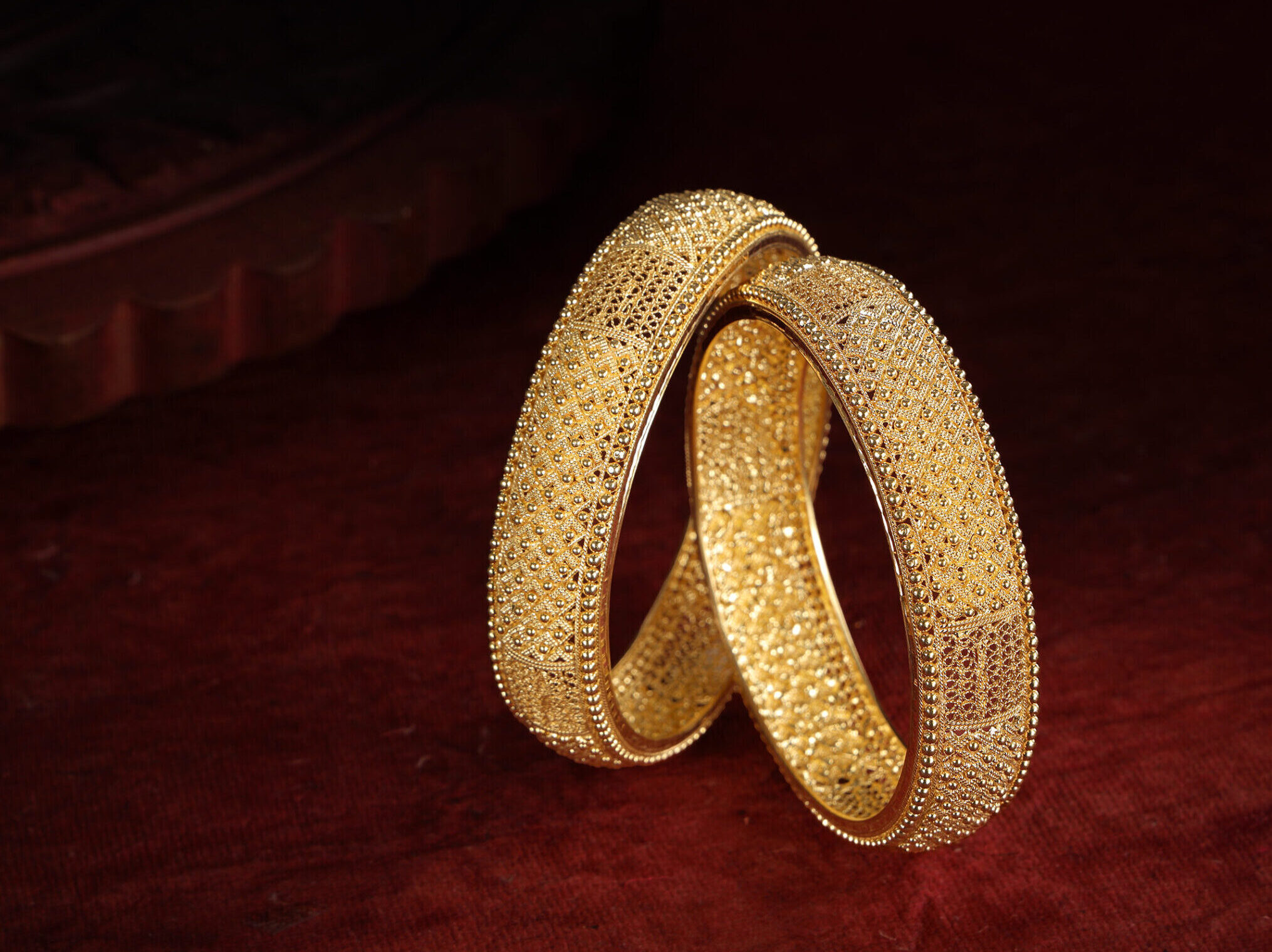 Premium gold bangle jewelry photography with dramatic lighting and luxury styling