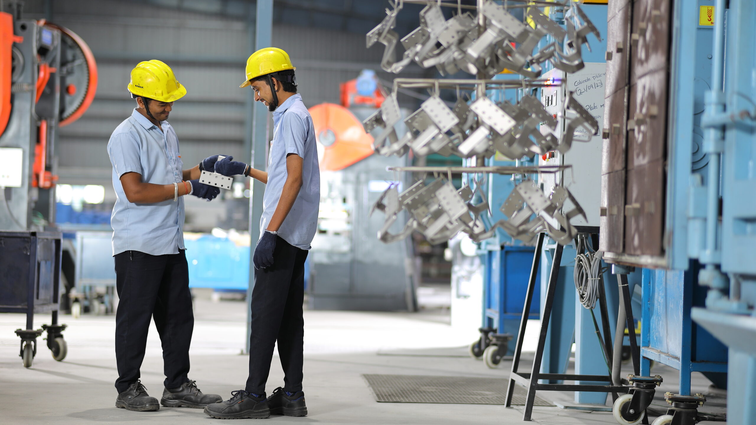 Industrial workers discussing operations inside factory production environment