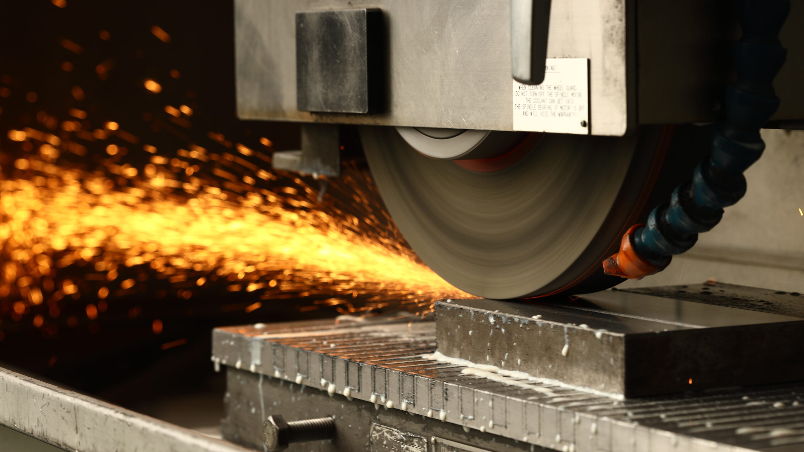 Industrial machine cutting metal with sparks during factory production process